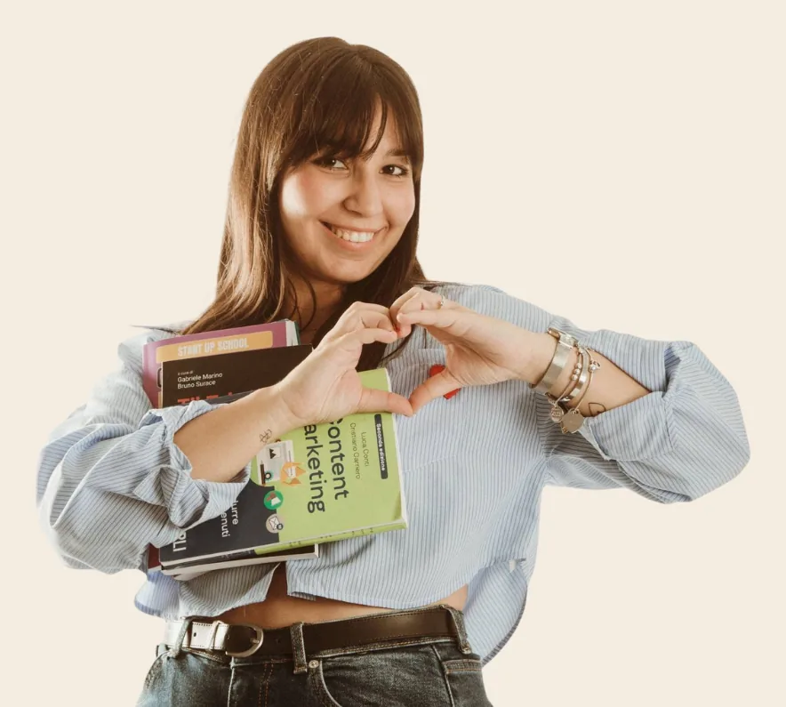 Giada Beltrame sorride e fa un cuore con le mani, con un libro sottobraccio